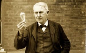Thomas Edison em seu laboratório, focado em uma invenção, simbolizando persistência e inovação.